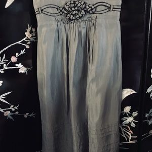 Woven piece mounted on center of dress with lots of detailed work.